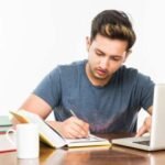 student studying JEE exam preparation admit card laptop books india