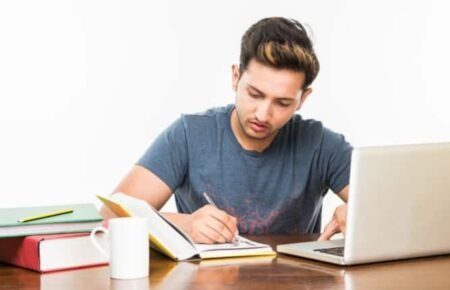 student studying JEE exam preparation admit card laptop books india