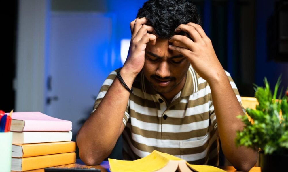 student stressed studying books exam pressure india late night study