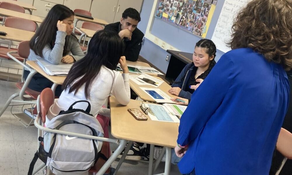 Students participating in a financial literacy and money management session in a school classroom.