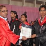 University students receiving degree certificates during graduation.