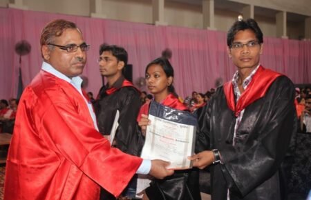 University students receiving degree certificates during graduation.
