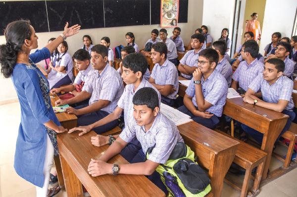 Students using newly designed textbooks in a secondary school classroom.