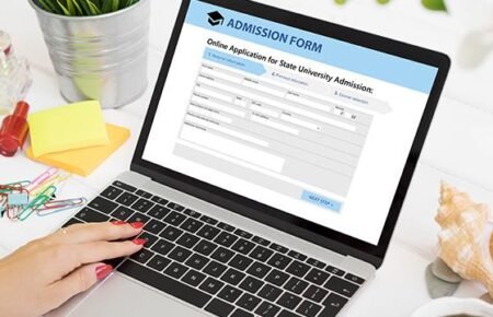 A student completing online university re-registration using a laptop.