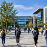 Modern university campus with students walking between academic buildings during the start of a new academic year.